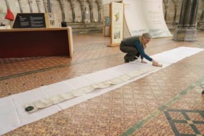 Cathedral_Archivist_Emily_Naish_unrolls_Robert_de_Cardevilles_19ft_scroll_-_Photo_by_Ash_Mills_-_Copy.jpg